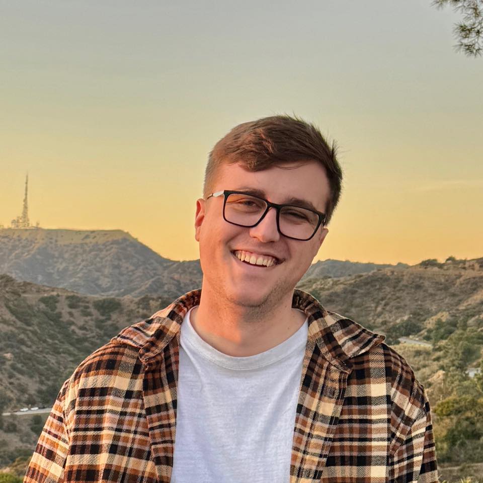 Zachary Stallings smiling in front of the Hollywood hills at sunset
